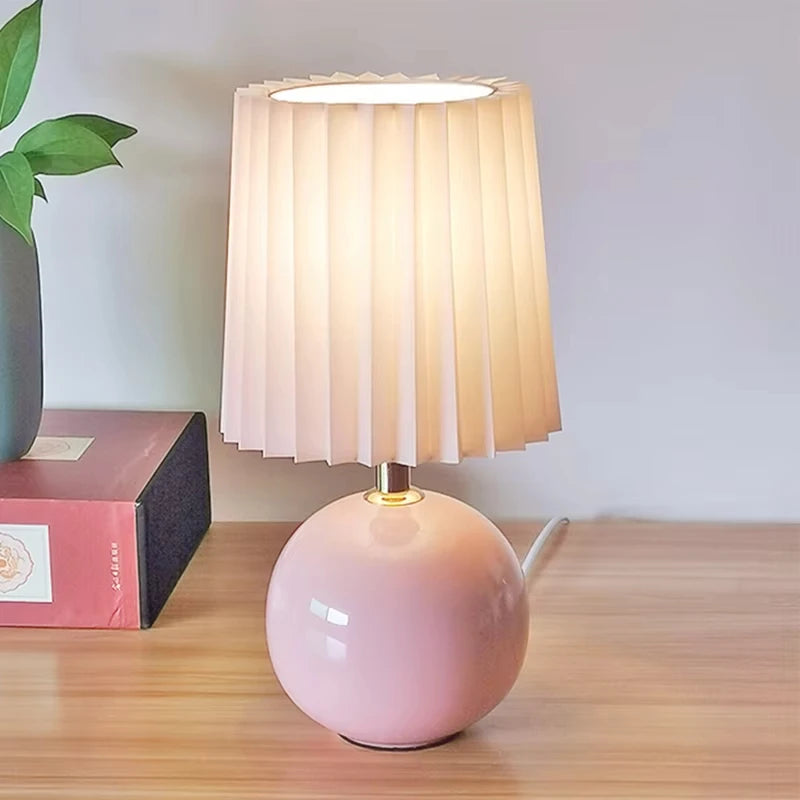 Lampe pied boule en céramique et abat-jour plissé – Marsanne allumée