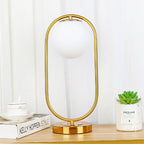 Lampe globe opalin dans un anneau, doré ou noir – Lugano, vue d’ambiance