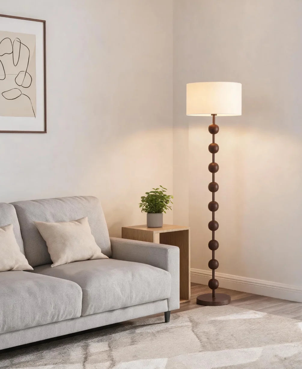 Lampadaire pied en perles de bois et abat-jour tambour – Lioux dans un intérieur