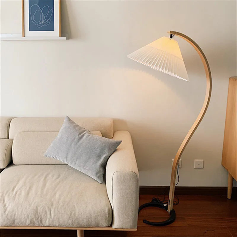 Lampadaire arc en bois courbé et abat-jour plissé – Mougins dans un intérieur