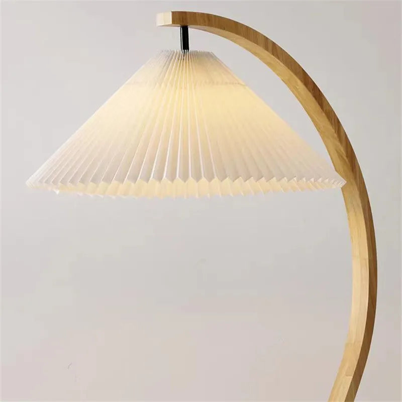 Lampadaire arc en bois courbé et abat-jour plissé – Mougins allumé