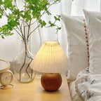 Lampe abat-jour plissé et pied boule en bois – Conques dans un intérieur