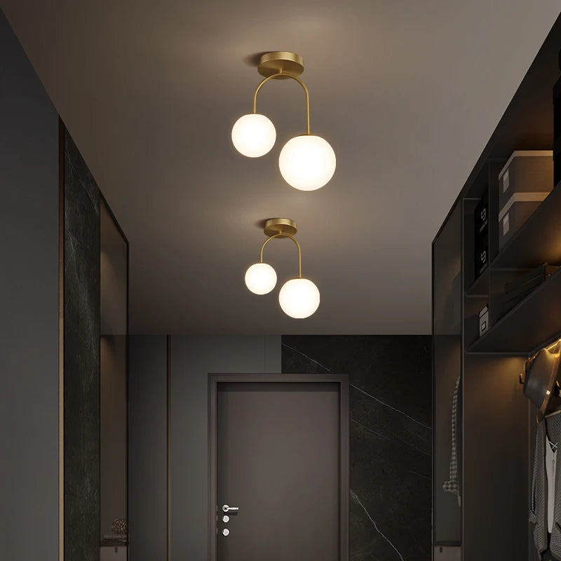 Plafonnier arceau en laiton et deux globes opalins – Passy, vue d’ambiance