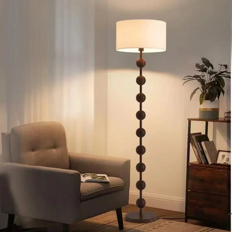 Lampadaire pied en perles de bois et abat-jour tambour – Lioux allumé
