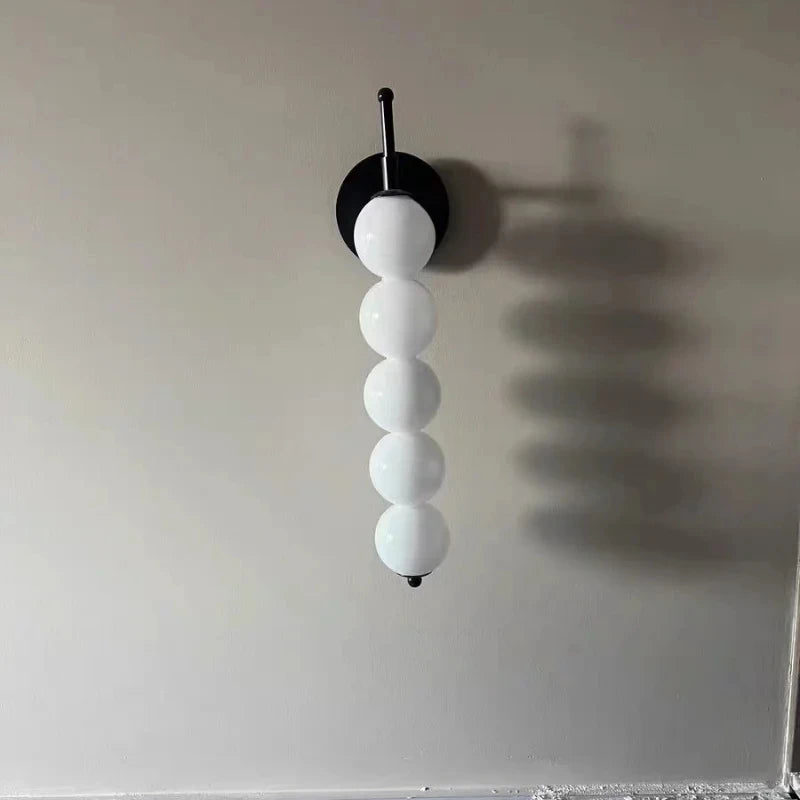Applique colonne de globes opalins, dorée ou noire – Pézenas, vue d’ambiance