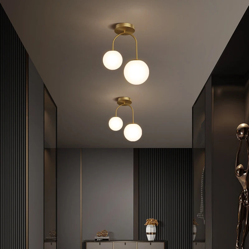 Plafonnier arceau en laiton et deux globes opalins – Passy dans un intérieur