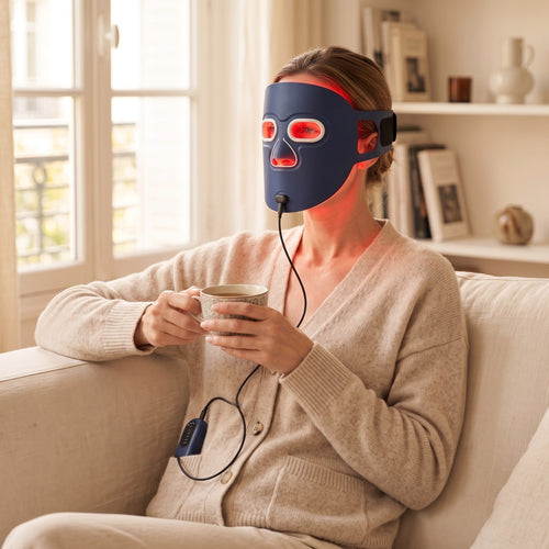 Masque Aurore porté sur le canapé avec une tasse de thé, télécommande glissée à la poche du gilet