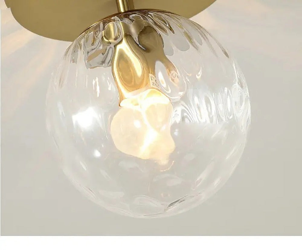 Petit plafonnier globe de verre et platine dorée – Mouffetard allumé
